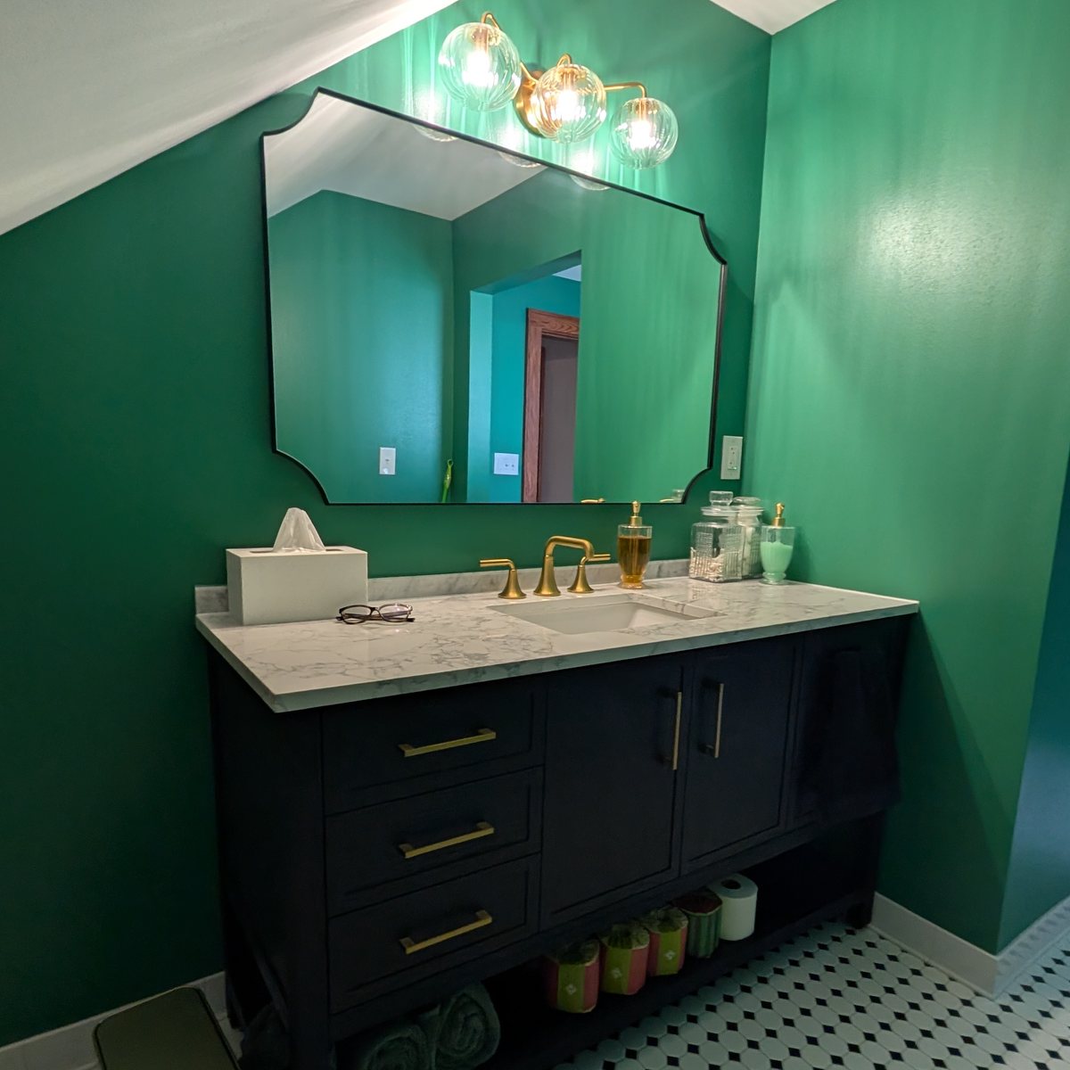 Bathroom painted deep emerald around a black vanity
