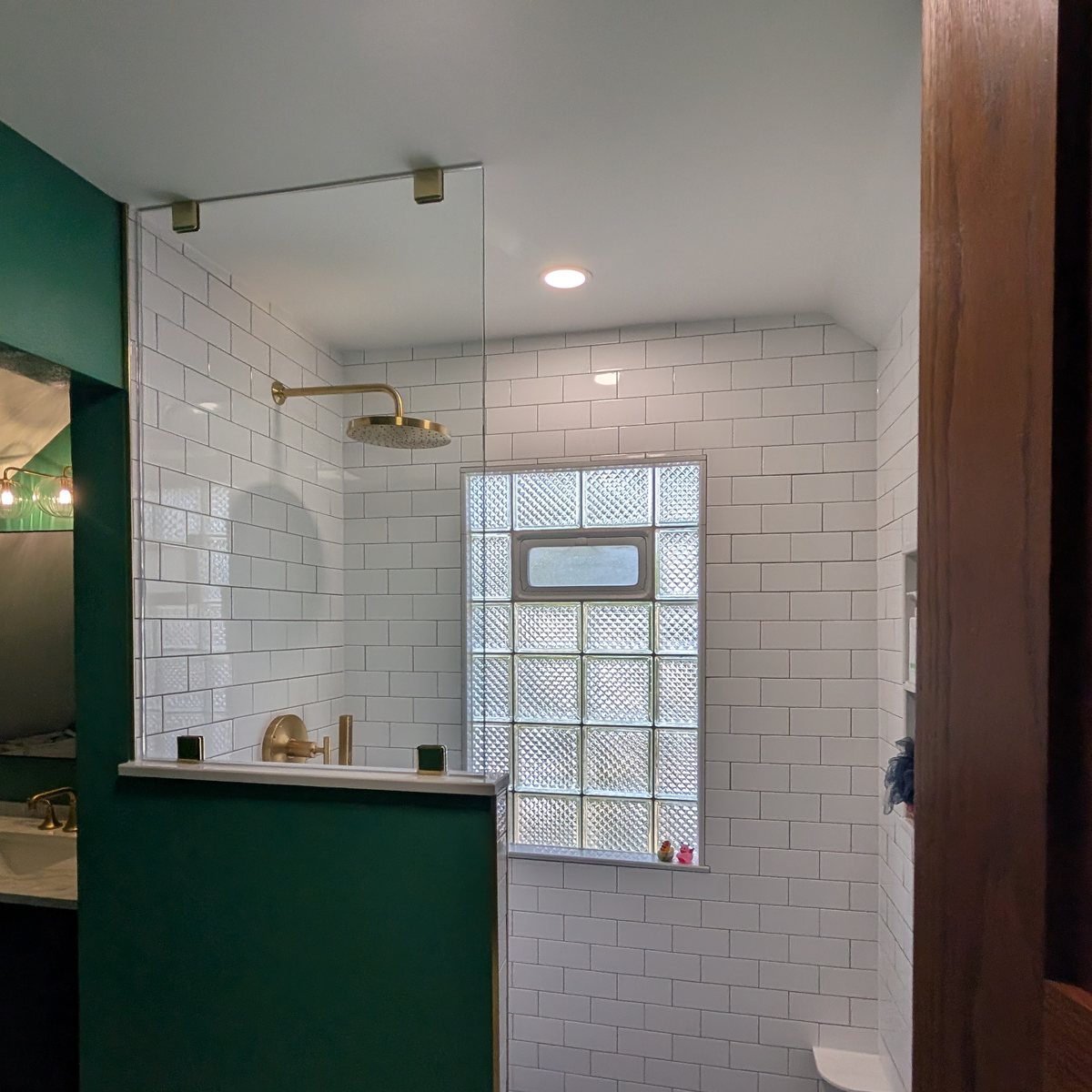Bathroom vanity in green beside a white tiled shower
