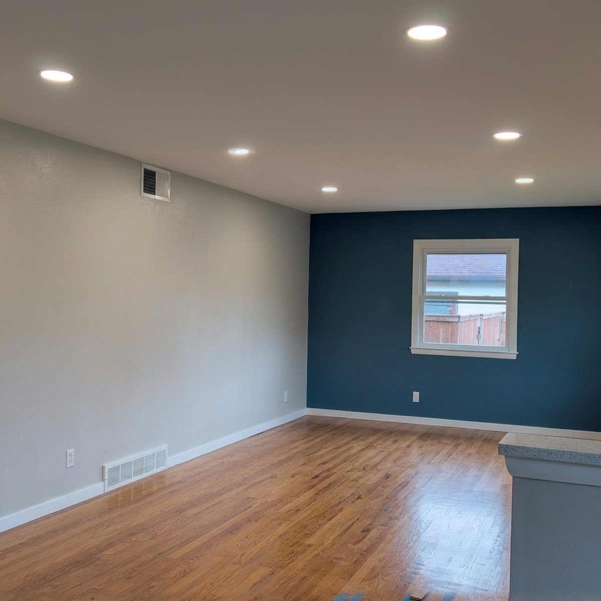 Room with a deep teal accent wall and a freshly painted ceiling