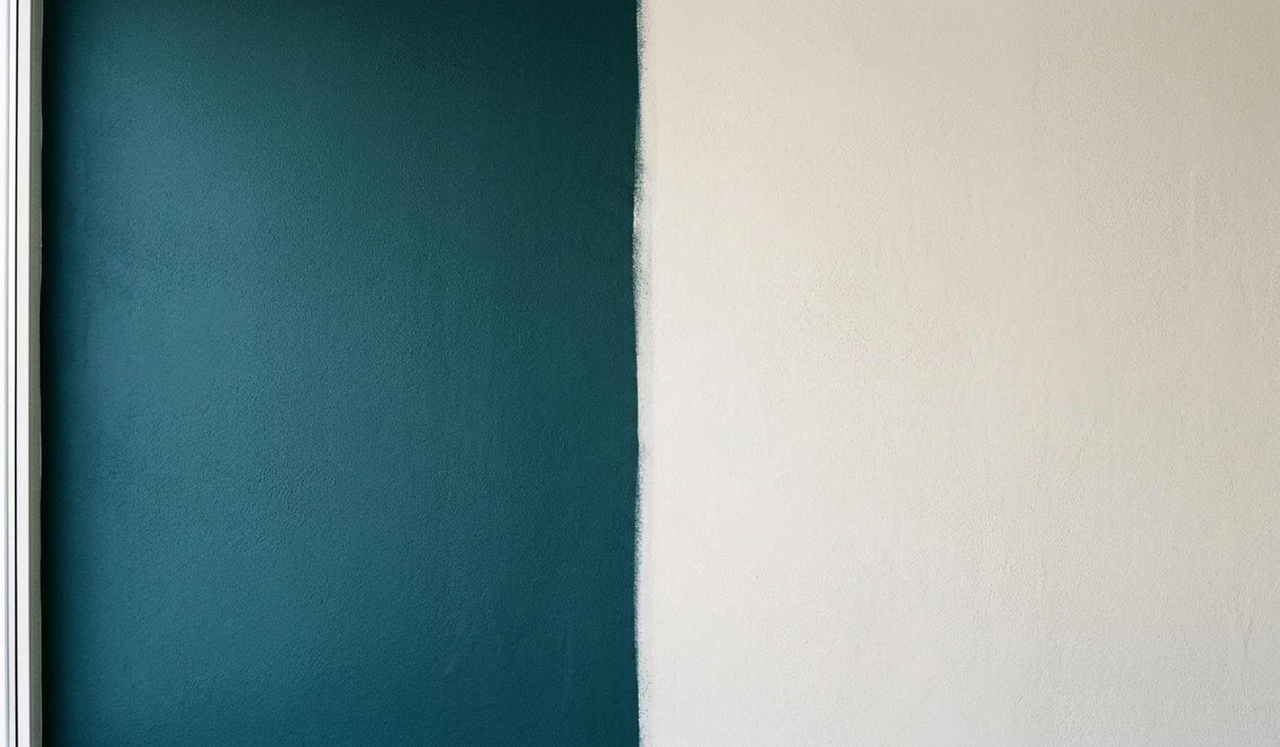 A deep blue-green painted wall meeting a chalky off-white one