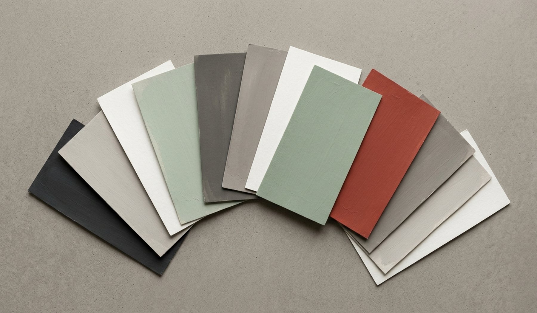 Painted colour sample cards fanned out across a grey surface