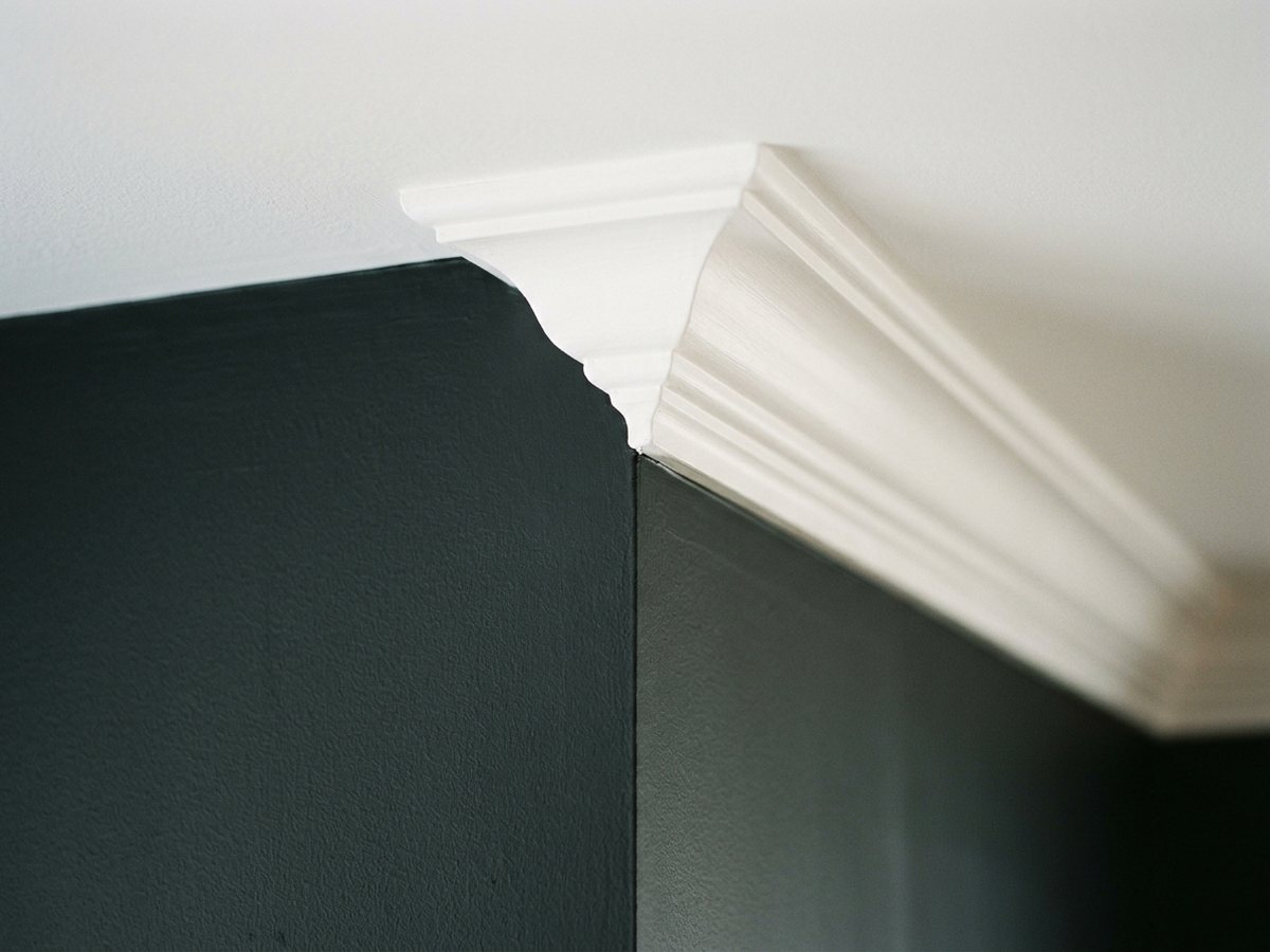 A sharp cut line where a charcoal wall meets white crown moulding